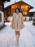 Model wearing the beige Plush Faux Fur Collar Coat in a snowy village