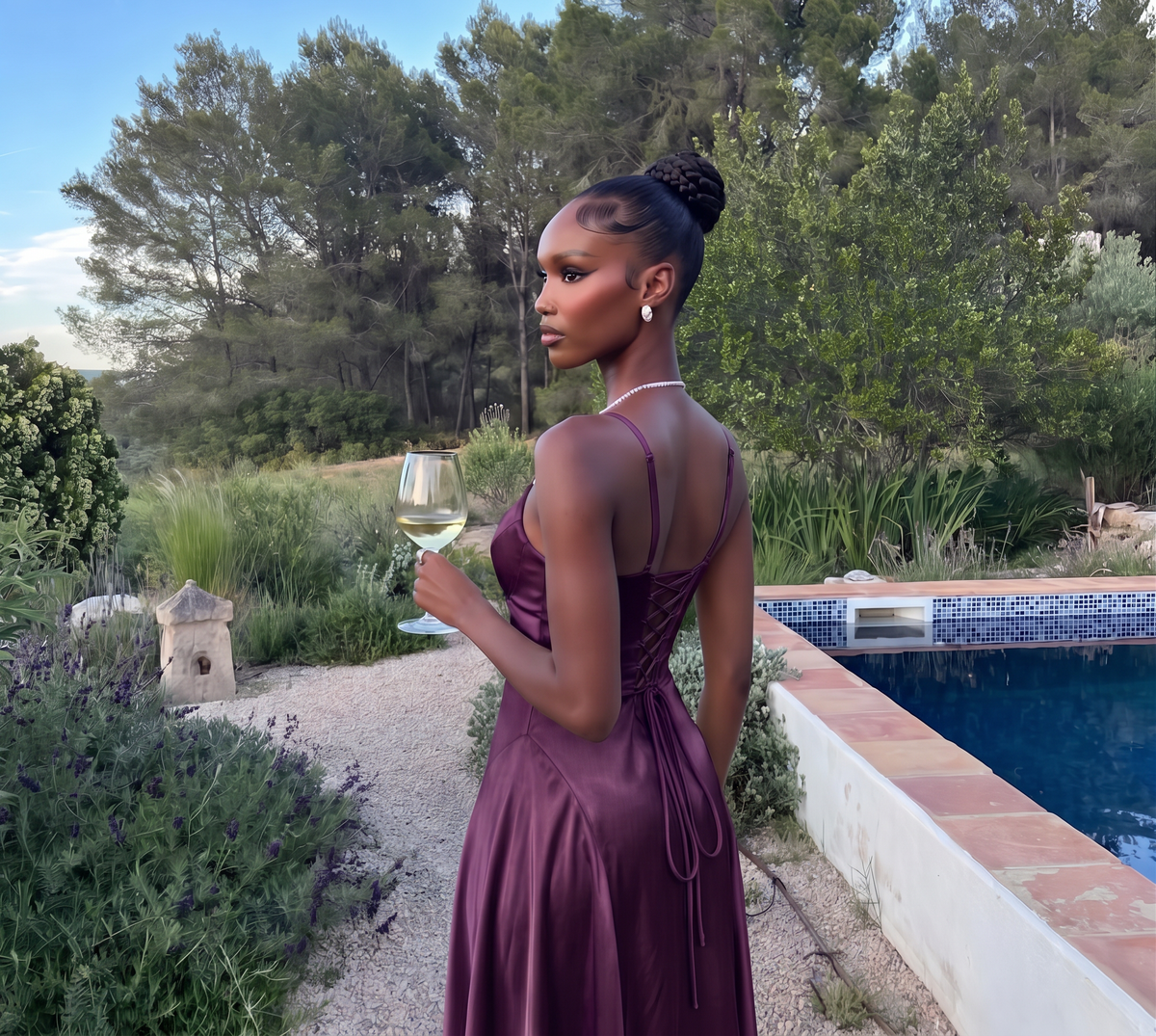 Deep purple satin maxi dress worn in a garden, back view